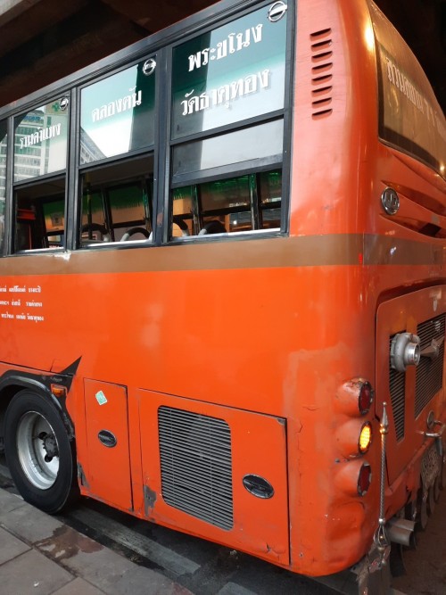 An orange bus in Sukhumvit waits for fares