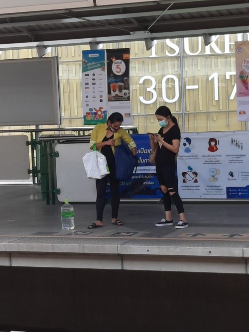 Two conmuters and a jug of drinking waters. Bangkok's fresh water supply is dwindling with the drought.