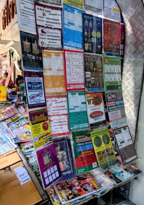 A newspaper agent's stand with a display of numerology and fortune-telling pamphlets for winning the lottery.