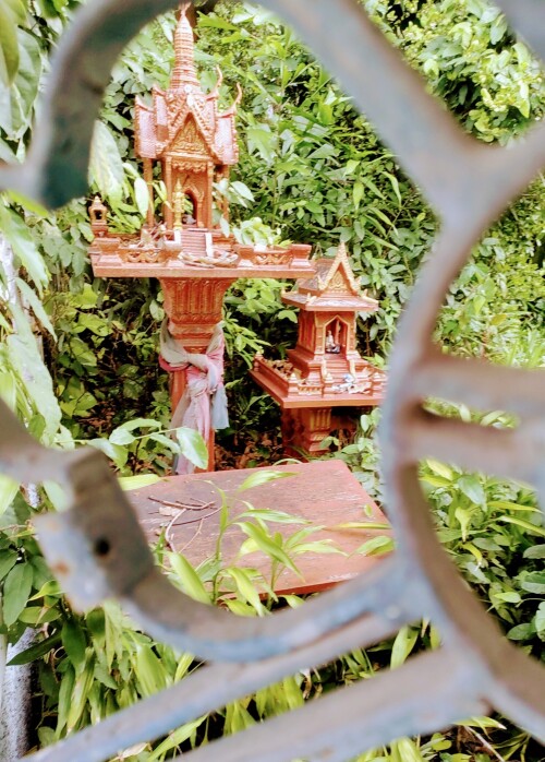 A spirit house in the yard of an abandoned home in Bangkok.