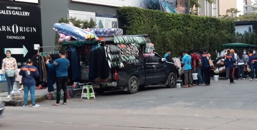 Construction workers buy clothes, soap, shoes and essentials from a pick-up truck shop before starting their work shift.